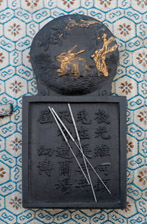 Needles for acupuncturist shown on antique Chinese ink stone